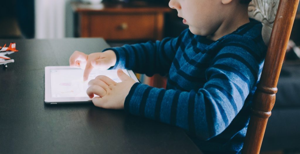 Bright child learning how to use ipad